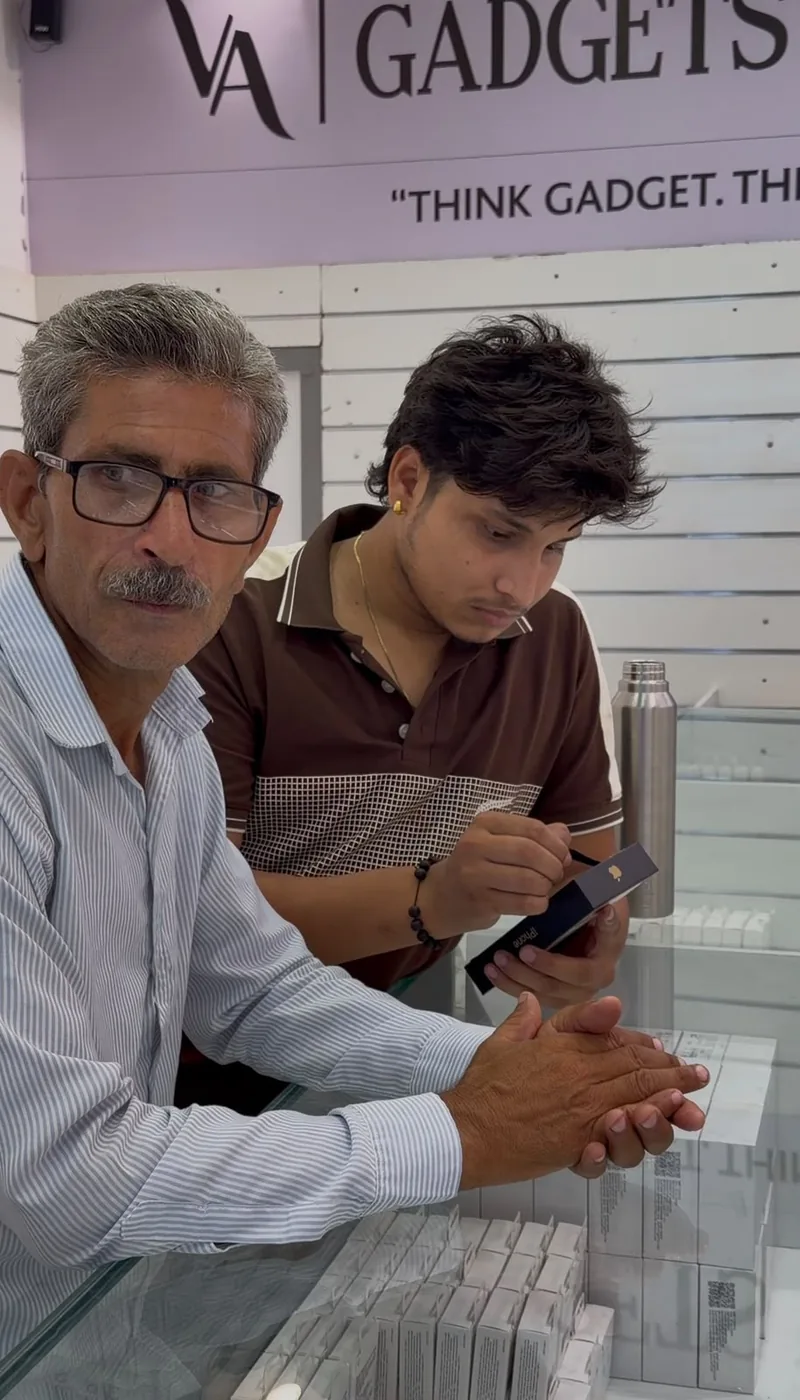 Two customers at the VA Gadgets World counter collecting a new iPhone together.