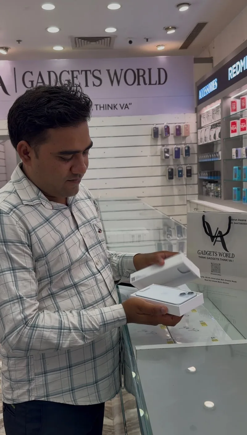 A customer at the VA Gadgets World counter unboxing a new sealed iPhone.