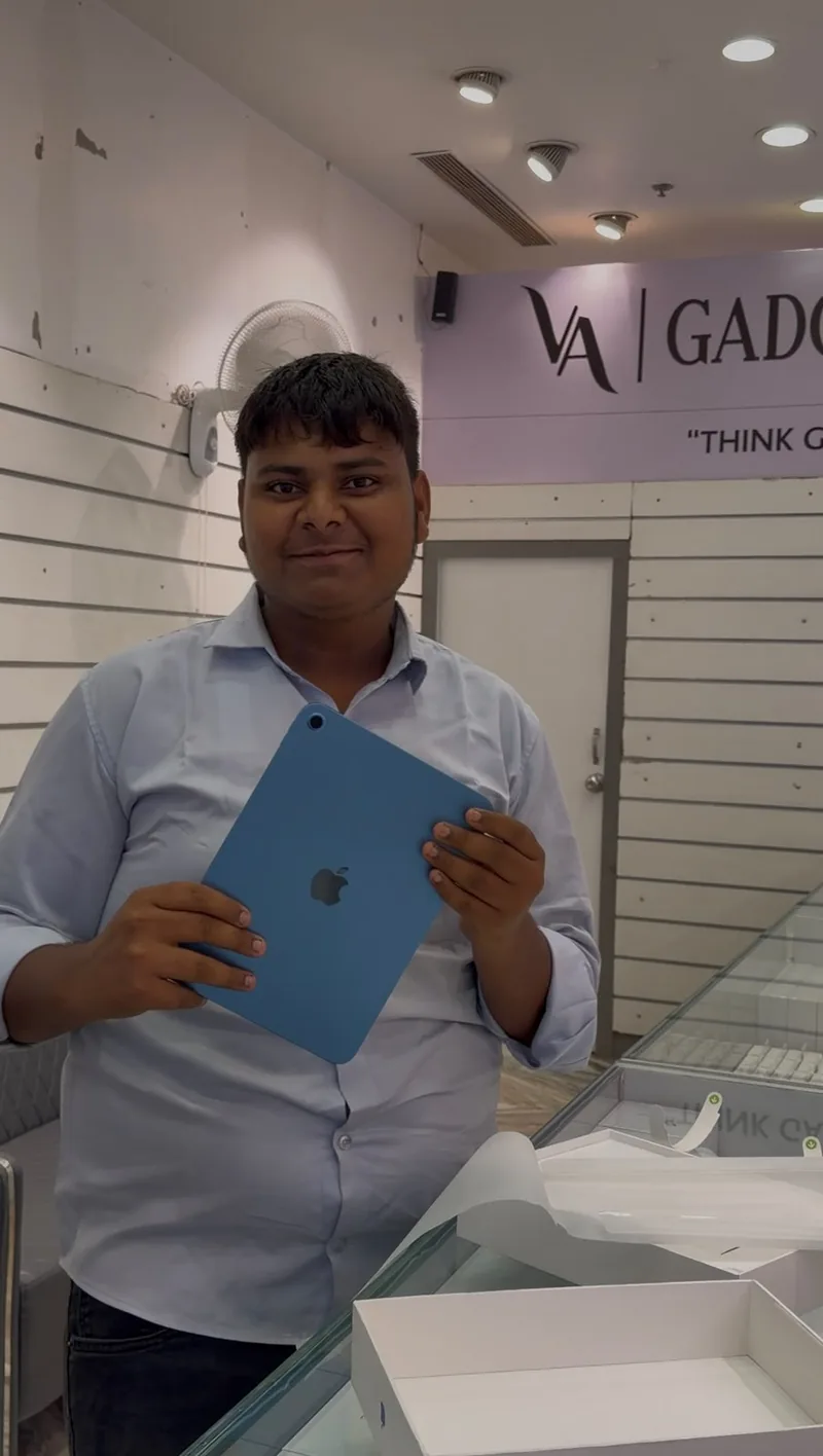 A customer at the VA Gadgets World counter with a new blue Apple iPad.